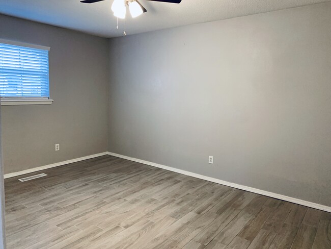 Master Bedroom, newly renovated with grey walls and beautiful grey porcelain wood plank tile. - 104 E Knoxville St