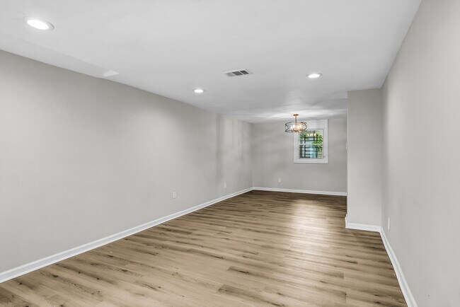 Open concept living room and kitchen eating area has brand new flooring - 844 E 37th St