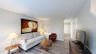 Located at 1055 Cedar Creek Dr in Monroe, Michigan, this two-bedroom, two-bathroom home is thoughtfully laid out across two floors. The main level offers a welcoming open-concept design, where the living room, dining area, and kitchen flow seamlessly together. The living room features smooth hardwood-style flooring, neutral gray walls, and a large picture window that fills the space with natural light. A hallway connects the living area to the rest of the main floor, lined with crisp white doors leading to additional rooms and closet storage.

The kitchen is well-appointed with white shaker-style cabinetry, stainless steel appliances, and a peninsula counter with a clean white surface — ideal for casual dining or meal prep. Adjacent to the kitchen, the dining area accommodates a full dining set and includes a window overlooking the outdoors, enhancing the bright and airy atmosphere.

Upstairs, the primary bedroom impresses with vaulted ceilings that lend a sense of openness, complemented by soft carpeting and a calm, neutral palette. The second bedroom is equally inviting, featuring dual windows that bring in generous natural light and serene outdoor views. Both bathrooms are clean and functional, with the main bath offering a shower-tub combination. Throughout, the home maintains a consistent, modern aesthetic with durable flooring, neutral tones, and ample natural light.