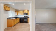Located at 4950 Hayter Ave in Lakewood, California, this single-story, 2-bedroom, 1-bathroom home offers a well-organized layout designed for comfortable everyday living. Wood-look flooring runs throughout the entire home, providing a cohesive and easy-to-maintain surface in every room.

The living room is generously proportioned, featuring crown molding, a ceiling fan, and a large front-facing window that fills the space with natural light and offers views of the neighborhood. A wall-mounted AC unit provides climate control.

The kitchen is a functional highlight, showcasing warm honey-toned cabinetry, dark granite countertops, recessed lighting, and a full suite of black appliances including a gas range, dishwasher, and over-the-range microwave. A window above the sink brings in additional natural light.

Both bedrooms are well-sized, each equipped with a ceiling fan and mirrored sliding closet doors that add depth and storage. The primary bedroom is particularly comfortable in scale. A hallway connects the bedrooms to the shared bathroom, which features a granite-topped wood vanity, a window for natural ventilation, and wood-look flooring consistent with the rest of the home. Clean, neutral tones throughout create a bright and welcoming atmosphere.