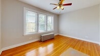 Located at 7526–7536 S Colfax Ave in Chicago, IL, this 4-bedroom, 1-bathroom unit offers a practical and well-organized single-floor layout. Throughout most of the unit, warm-toned hardwood floors provide a classic Chicago character, complemented by neutral light gray walls and clean white trim and baseboards.

The four bedrooms vary in size, with the primary bedroom offering a comfortable footprint, large multi-pane windows that invite abundant natural light, a ceiling fan, and a classic cast-iron radiator. Additional bedrooms feature hardwood floors, closets with white panel doors, and windows with neighborhood views. The layout connects rooms through two hallways, creating a clear circulation path.

A notable feature of this unit is the presence of two kitchens. One kitchen showcases updated gray shaker-style cabinetry, granite-look countertops, a stainless undermount sink with a matte black faucet, and light tile flooring — offering a clean, modern aesthetic. The shared bathroom includes cream tile flooring, a dark wood vanity with a framed mirror, and a window providing natural ventilation.

The overall ambiance is clean, functional, and move-in ready, with a mix of classic architectural elements and updated finishes throughout.