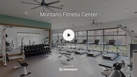 Located in Moreno Valley, California, this modern fitness center offers a comprehensive exercise facility designed to support a wide range of workout routines. The single-floor space is generously sized, providing ample room for both cardio and strength training activities.

Floor-to-ceiling windows line the perimeter of the cardio zone, flooding the space with natural light and offering views of the surrounding palm trees and rocky hillside landscape. Large ceiling fans are installed throughout, ensuring comfortable airflow during workouts. Recessed lighting complements the bright, open atmosphere.

The cardio area is well-stocked with a row of treadmills, stationary bikes, ellipticals, and stair climbers, all positioned to take advantage of the expansive outdoor views. A dedicated free weights section features a full rack of dumbbells, adjustable benches, and barbells, framed by a large wall mirror accented with wood trim. The walls in this area are painted in a calming sage green with decorative arch details, lending the space a stylish, contemporary feel.

A separate functional training zone includes a multi-cable functional trainer, TRX suspension straps, and open floor space for stretching or group exercise. Stability balls and additional accessories round out the offerings. The flooring transitions from rubberized surfaces in high-traffic zones to carpet in strength areas, providing appropriate support throughout.