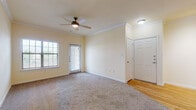 Located at 2417 Colorado St in Mission, Texas, this single-floor residence offers a well-designed layout that balances comfort and functionality. The living area is generously sized, featuring plush wall-to-wall carpeting, crown molding, and a ceiling fan with light fixture. Natural light filters in through blinded windows, creating a bright and inviting atmosphere. A door provides direct access to an outdoor patio area, enhancing the sense of openness.

The kitchen is a central highlight, boasting warm wood-tone hardwood flooring, light cabinetry, and dark granite countertops. A peninsula island with a built-in sink and additional counter space serves as both a prep area and a casual gathering point. Black appliances — including a refrigerator, electric range, microwave, and dishwasher — complement the mosaic tile backsplash for a cohesive, modern look. A closet pantry adds practical storage.

The bedroom continues the carpeted flooring theme, complete with a ceiling fan and ample natural light. The bathroom features a soaking tub and shower combination with clean white tile surround accented by a neutral border, a dark granite vanity countertop, and a mirrored medicine cabinet. Throughout the unit, crown molding and consistent warm yellow-toned walls provide a cohesive and welcoming aesthetic.