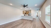 Located at 1340 County Road 1106 in Anna, TX, this thoughtfully designed single-story home offers a clean, modern aesthetic throughout its well-organized floor plan. Warm-toned luxury vinyl plank flooring flows continuously across the living areas, complementing the neutral white walls and recessed lighting found throughout.

The open-concept living and kitchen area serves as the heart of the home. A ceiling fan anchors the spacious living room, which receives natural light through well-placed windows. The kitchen features light wood cabinetry, a white subway tile backsplash, white quartz countertops, stainless steel appliances including a French door refrigerator, and a peninsula with an undermount sink — ideal for both cooking and casual dining.

The generously sized primary bedroom includes a ceiling fan, recessed lighting, and direct access to a walk-in closet outfitted with built-in shelving and hanging rods for ample organized storage. The bathroom is finished with a wood-toned vanity, white quartz countertop, and a glass-enclosed walk-in shower tiled in white subway tile with wood-look flooring.

Additional spaces include a dedicated laundry area, utility room, pantry, entrance, and hallway, ensuring practical functionality throughout. The home's clean finishes and efficient layout make it a well-appointed residence in Anna, TX.