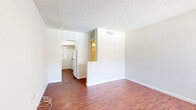 Located at 475 E Foothill Blvd in Pomona, California, this efficient single-floor unit offers a thoughtfully arranged layout comprising a living room, kitchen, bathroom, and closet. Warm, rich hardwood-style flooring runs throughout the main living areas, creating a cohesive and inviting atmosphere. The living room is bright and open, featuring a large window fitted with vertical blinds that allows generous natural light to filter in, along with views of the surrounding outdoor area, including a glimpse of a pool. A textured ceiling and clean white walls give the space a simple, neutral aesthetic. The kitchen is functionally appointed with a gas range, overhead microwave, and a window overlooking greenery, making it a practical cooking space. The bathroom is well-maintained and features a tiled tub-shower combination enclosed by sliding glass doors, a white vanity with sink, and a frosted window for natural light and privacy. A dedicated closet provides convenient storage. The unit's straightforward, clean design and consistent flooring throughout make it a practical and comfortable space suited for efficient everyday living in the heart of Pomona.