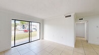 Located at 7050 Northwest 179th Street in Hialeah, FL, this single-floor residence offers a well-organized layout with 2 bedrooms, 2 bathrooms, a combined kitchen and living area, a hallway, and a closet. Light-colored ceramic tile flooring runs consistently throughout the entire space, lending a clean and cohesive look to every room.

The living room is an open, bright area featuring large sliding glass doors that flood the space with natural light and provide direct views of the surrounding greenery outside. The kitchen is efficiently designed with cream-toned cabinetry, a granite-style countertop, a stove, and a refrigerator. A peninsula counter separates the kitchen from the living and dining area, offering additional workspace and a natural division between the two zones.

Both bedrooms are bright and simply designed, each featuring windows that invite natural light and neighborhood views. The clean white walls and tile flooring create a neutral, versatile environment in each room.

The bathrooms are functionally appointed, featuring tile flooring, a vanity with a granite-style countertop, a wide mirror with overhead lighting, and a bathtub with tiled surround walls. The overall ambiance of this residence is clean, bright, and straightforward, making it a practical and comfortable living space.