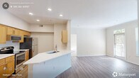 Located in Raleigh, NC, this well-appointed one-bedroom, one-bathroom residence offers a thoughtfully designed single-floor layout. The open-concept kitchen and living area serves as the heart of the home, featuring warm maple cabinetry, stainless steel appliances including a range, microwave, and refrigerator, and a peninsula with a single-basin sink that provides additional prep space and casual seating. Light hardwood-style flooring flows throughout the main living areas, complementing the neutral, warm-toned walls and recessed lighting overhead. The living room is bathed in natural light from large windows and a glass-panel door, and is anchored by a handsome tile-surround fireplace with built-in shelving — an ideal space for relaxing or entertaining. The generously sized bedroom features plush carpeting, dual windows, a ceiling fan, and multiple closets offering excellent storage. The bathroom is clean and functional, with a full tiled tub-shower combo, wood-style flooring, and a vanity with countertop. A dedicated in-unit laundry area with a full-size washer and dryer adds everyday convenience. With four closets spread throughout, storage is never a concern in this efficiently designed Raleigh residence.