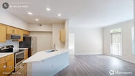 Located in Raleigh, NC, this well-appointed one-bedroom, one-bathroom residence offers a thoughtfully designed single-floor layout. The open-concept kitchen and living area serves as the heart of the home, featuring warm maple cabinetry, stainless steel appliances including a range, microwave, and refrigerator, and a peninsula with a single-basin sink that provides additional prep space and casual seating. Light hardwood-style flooring flows throughout the main living areas, complementing the neutral, warm-toned walls and recessed lighting overhead. The living room is bathed in natural light from large windows and a glass-panel door, and is anchored by a handsome tile-surround fireplace with built-in shelving — an ideal space for relaxing or entertaining. The generously sized bedroom features plush carpeting, dual windows, a ceiling fan, and multiple closets offering excellent storage. The bathroom is clean and functional, with a full tiled tub-shower combo, wood-style flooring, and a vanity with countertop. A dedicated in-unit laundry area with a full-size washer and dryer adds everyday convenience. With four closets spread throughout, storage is never a concern in this efficiently designed Raleigh residence.