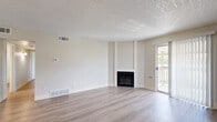 Located at 7440 E Harvard Ave in Denver, CO, this single-floor residence offers three bedrooms and two bathrooms within a efficiently arranged floor plan. The open living room serves as the heart of the home, showcasing light gray wood-look flooring, neutral wall tones, and a textured ceiling throughout. A corner fireplace anchors the living space, while a sliding glass door provides direct access to a private balcony, allowing natural light to fill the room.

The galley-style kitchen features white shaker cabinetry with matte black hardware, white countertops, stainless steel appliances including an electric range and dishwasher, and a pass-through that connects to the living area. A ceiling fan overhead adds functionality to the adjacent dining and living zone.

The generously sized primary bedroom includes its own en-suite bathroom and ample closet space. The additional bedrooms are well-proportioned, each with light flooring, natural window light, and sliding-door closets with built-in rods. The bathrooms are finished with clean white subway tile and contemporary fixtures. A hallway connects the bedrooms and shared spaces, keeping the layout organized and practical.