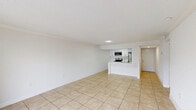 Located at 4400–4550 W 16th Ave in Hialeah, FL, Unit 616 is a well-appointed 3-bedroom, 2-bathroom residence thoughtfully laid out across a single floor. Light-toned ceramic tile flooring runs throughout, creating a cohesive and easy-to-maintain aesthetic. The combined kitchen and living area serves as the heart of the home, featuring a sleek kitchen with white cabinetry, quartz countertops, stainless steel appliances including a range, microwave, and refrigerator, and a peninsula with an integrated sink — ideal for both cooking and casual dining. The living area is open and airy, accented by crown molding and a textured ceiling. A sliding glass door leads to a private balcony with open views of the surrounding community. The primary bedroom is generously sized, offering an en-suite bathroom and direct access to a closet. Two additional bedrooms provide ample space, each with access to hallways and closet storage. Both bathrooms are finished in crisp white, featuring tub-shower combinations and tile flooring. Two hallways connect the rooms efficiently, enhancing flow throughout the unit. The overall ambiance is clean, bright, and move-in ready.