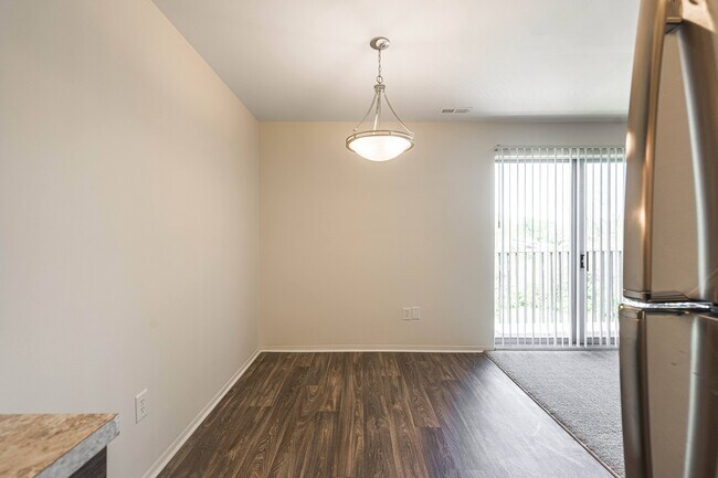 Amplio comedor con luz natural y pisos de madera en Knottingham Apartments en Clinton Township, MI - Knottingham Apartments