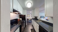 Located at 4250 Albany Dr in San Jose, California, this single-floor residence offers a well-organized layout designed for comfortable everyday living. The galley-style kitchen is a functional highlight, featuring white shaker cabinetry, dark countertops, black appliances including an electric range and dishwasher, a stainless steel sink, and durable wood-look flooring. A stylish flush-mount ceiling fixture provides bright overhead lighting, and the kitchen opens directly into a dedicated dining area. The dining space is cozy and defined, with soft blue-toned walls, dark hardwood-style flooring, and room for a round table with seating for four. The living room offers an inviting atmosphere with neutral-toned walls, a textured ceiling, and dark flooring, providing a comfortable setting for relaxation. The bedroom is finished with plush carpeting, soft blue accent walls, a textured ceiling, and a window that allows natural light to filter in. The bathroom includes a single-basin vanity with a large mirror, dark countertop, and a shower-tub combination. Throughout the residence, a cohesive color palette of whites, blues, and neutrals creates a calm and livable environment well-suited for the San Jose area.