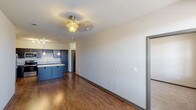 This single-floor residence is thoughtfully designed with a functional, open layout that connects the living and kitchen areas seamlessly. The kitchen serves as a central highlight, featuring dark espresso cabinetry paired with light granite countertops, a large central island ideal for dining or food preparation, and a full suite of stainless steel appliances including a refrigerator, electric range, microwave, and dishwasher. A built-in wine rack adds a distinctive touch, while pendant lighting over the island and track lighting above provide ample illumination. Rich hardwood-style flooring flows throughout the kitchen and living areas, complementing the neutral wall tones.

The living area is open and bright, benefiting from natural light through sizable windows and a ceiling fan fixture overhead. The bedrooms are carpeted for added comfort, each featuring ceiling fans and generous wall space. One bedroom includes multiple windows with blinds, allowing for natural light and outdoor views.

The bathroom is well-equipped with a granite-topped vanity, a full soaking tub with shower surround, and coordinating dark cabinetry. Throughout the unit, dark-trimmed doors and consistent finishes create a cohesive, modern aesthetic.