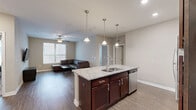Located at 801 W 4th Ave in Stillwater, Oklahoma, this single-story residence offers a well-designed layout with three bedrooms and three bathrooms. The kitchen is a standout feature, showcasing rich dark wood cabinetry, granite countertops, and a full suite of stainless steel appliances including a refrigerator, range, microwave, and dishwasher. A large central island with pendant lighting and bar seating provides both additional prep space and a casual dining area. Wood-look flooring flows through the kitchen and living spaces, creating a cohesive and easy-to-maintain aesthetic. The living room is bright and open, featuring a ceiling fan and windows that allow natural light to fill the space. Each bedroom is finished with plush carpet and ceiling fans, offering a comfortable retreat. The primary bedroom includes a private en-suite bathroom, while the additional bedrooms are served by well-appointed bathrooms each featuring a tub-shower combination. Neutral wall tones throughout lend a clean, versatile backdrop suitable for a variety of décor styles. The thoughtful floor plan maximizes functionality, making efficient use of every square foot in this comfortable Stillwater home.