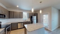 This modern single-story home in Humble, TX (77346) offers a well-designed layout with contemporary finishes throughout. The open-concept kitchen is a standout feature, showcasing dark wood cabinetry, granite countertops, and a large center island with pendant lighting overhead. Stainless steel appliances — including a refrigerator, dishwasher, range, and microwave — complement the clean aesthetic, while light wood-style flooring ties the space together seamlessly.

The living and bedroom areas provide a comfortable retreat, with plush carpet flooring in the bedrooms and ceiling fans for year-round comfort. Large windows dressed with blinds allow ample natural light to fill each room, creating a bright and airy atmosphere. The rooms are well-proportioned, offering flexible space for a variety of furniture arrangements.

The bathroom is clean and functional, featuring a tub-shower combo with tile surround, granite-topped vanity, and neutral wall tones that contribute to a calm, cohesive look. Throughout the home, consistent use of neutral colors and modern hardware creates a polished, move-in-ready environment. This single-floor layout provides convenient accessibility and a practical flow between living spaces, making it an ideal residence in the Humble, TX area.