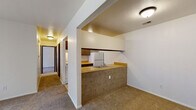 Located at 1652 Leonard St NE in Grand Rapids, Michigan, this single-floor unit offers a practical and well-organized layout with a clean, neutral aesthetic throughout. The living room is a generous, carpeted space filled with natural light, anchored by a sliding glass door that opens to an outdoor balcony — an inviting feature that connects the interior to the outdoors. Adjacent to the living area, a half-wall peninsula defines the kitchen, which features warm butcher block countertops, dark cabinetry, tile flooring, and white appliances including a refrigerator, electric range, and dishwasher. The galley-style kitchen layout maximizes efficiency while maintaining an open feel with the adjoining living space. The bedrooms are comfortably sized, each with plush carpeting and sliding-door closets offering ample storage. The full bathroom is well-appointed with tile flooring, a vanity with under-sink cabinetry, a lighted mirror, and a shower-tub combination. A hallway connects all rooms seamlessly, contributing to a functional and cohesive flow throughout the unit. The overall ambiance is bright, clean, and move-in ready, making this a straightforward and practical space in a convenient Grand Rapids neighborhood.