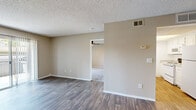 Located in Escondido, CA, this single-floor, one-bedroom, one-bathroom residence offers a practical and well-organized layout. The living room is bright and open, featuring wood-style laminate flooring, a textured ceiling, a ceiling fan with light, and a sliding glass door that provides access to an outdoor balcony and fills the space with natural light. The layout flows directly into the kitchen, which is equipped with white cabinetry, speckled laminate countertops, a dishwasher, and a range, all set atop light wood-style flooring — creating a clean, efficient cooking space. The bedroom is comfortably sized, carpeted for warmth, and includes a ceiling fan, a window with vertical blinds for natural light and privacy, and neutral warm-toned walls. The bathroom is finished in a clean, all-white palette and features a full tub-shower combination with chrome fixtures and multiple grab bars for added accessibility, complemented by wood-style flooring and a vanity with a speckled countertop. Throughout the residence, neutral beige tones, white trim, and consistent flooring choices create a cohesive and move-in-ready environment suited for comfortable everyday living.