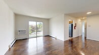 This one-bedroom, one-bathroom unit at 375 State St in Perth Amboy, NJ offers a well-organized and functional layout across a single floor. Rich, dark hardwood flooring runs throughout the living and bedroom areas, lending warmth and continuity to the space.

The living room is bright and open, highlighted by large sliding glass doors that invite natural light and offer views of the surrounding greenery. A wall-mounted air conditioning unit provides comfort year-round, complemented by baseboard heating.

The kitchen is efficiently designed in a galley style, featuring warm wood cabinetry, granite countertops, a stainless steel gas range, and a full-size refrigerator. A marble-style tile backsplash adds a refined touch, while a window over the counter brings in natural light.

The spacious primary bedroom includes two sliding-door closets, providing generous storage. The room's clean white walls and hardwood floors create a calm, neutral atmosphere.

The bathroom is tastefully finished with marble-style tile surrounds, a glass-enclosed tub and shower combination, and light flooring, giving it a clean, modern feel with natural light from a window.

A dedicated closet rounds out the layout, adding practical storage to this well-appointed unit in Perth Amboy, NJ.