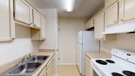 This single-story home in Milton, Florida offers a functional and comfortable layout designed for everyday living. The open living and dining area serves as the heart of the home, featuring light tile flooring, a chandelier overhead, and built-in shelving that adds both storage and character. A pass-through connects this space to the kitchen, enhancing the open feel.

The galley-style kitchen is efficiently arranged with cream-toned cabinetry, light countertops, a double stainless steel sink, and white appliances including a refrigerator and electric range. Light tile flooring continues throughout, and overhead lighting keeps the space bright and practical.

The bedrooms are carpeted for comfort and each include ceiling fans with light fixtures and windows that allow natural light to filter in, creating a calm and restful atmosphere.

The bathroom features large-format stone-look tile surrounding the tub and shower combination, paired with a vanity area that includes a single sink, light countertop, and mirror. Tile flooring completes the clean, cohesive look.

Throughout the home, a neutral color palette of warm beige and cream tones creates a cohesive and inviting ambiance, while textured ceilings add a classic touch consistent with the home's character.