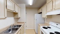 This single-story home in Milton, Florida offers a functional and comfortable layout designed for everyday living. The open living and dining area serves as the heart of the home, featuring light tile flooring, a chandelier overhead, and built-in shelving that adds both storage and character. A pass-through connects this space to the kitchen, enhancing the open feel.

The galley-style kitchen is efficiently arranged with cream-toned cabinetry, light countertops, a double stainless steel sink, and white appliances including a refrigerator and electric range. Light tile flooring continues throughout, and overhead lighting keeps the space bright and practical.

The bedrooms are carpeted for comfort and each include ceiling fans with light fixtures and windows that allow natural light to filter in, creating a calm and restful atmosphere.

The bathroom features large-format stone-look tile surrounding the tub and shower combination, paired with a vanity area that includes a single sink, light countertop, and mirror. Tile flooring completes the clean, cohesive look.

Throughout the home, a neutral color palette of warm beige and cream tones creates a cohesive and inviting ambiance, while textured ceilings add a classic touch consistent with the home's character.