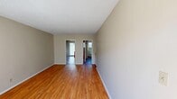 Located on Vassar Avenue in the Canoga Park neighborhood of Los Angeles, this single-floor, one-bedroom, one-bathroom unit offers a practical and comfortable layout. Warm hardwood-style flooring runs throughout, complemented by neutral-toned walls and textured ceilings that lend a classic residential feel.

The open living area is bright and well-proportioned, benefiting from natural light and providing a welcoming atmosphere. It connects seamlessly to the rest of the unit via a central hallway, which leads to the kitchen, bedroom, and bathroom.

The kitchen is equipped with rich wood cabinetry offering ample storage, a tile countertop with an integrated sink, and a white electric range with an over-the-range microwave. A window and door provide natural light and outdoor access, enhancing the functionality of the space.

The generously sized primary bedroom features a wall-mounted air conditioning unit and a sliding glass door that lets in natural light. Two closets offer substantial storage capacity.

The bathroom is clean and efficiently designed, featuring a white vanity with a tile countertop, dual mirrors, and chrome fixtures. A hallway connects all areas of the unit, ensuring a smooth and logical flow throughout the home.