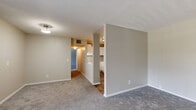 Located at 7147 Old Kings Rd S in Jacksonville, FL, this single-floor unit offers a well-organized layout designed for comfortable everyday living. The spacious living area is finished with plush gray carpeting and neutral-toned walls, creating a clean and versatile backdrop. A large sliding glass door floods the space with natural light and opens to a private patio overlooking lush greenery, seamlessly connecting the interior to the outdoors.

The kitchen is efficiently designed with white cabinetry, light countertops, a full suite of white appliances including a refrigerator and electric range, and durable wood-look vinyl flooring. A pass-through opening connects the kitchen to the living area, promoting an open and airy feel throughout.

The bedrooms are generously sized, each featuring soft carpeting, neutral walls, and windows with outdoor views that bring in ample natural light. Closet space is well-represented, with at least one bedroom offering a dedicated closet fitted with louvered bifold doors, a hanging rod, and a shelf.

The bathroom is cleanly appointed with a white vanity, medicine cabinet mirror, lighted vanity bar, and wood-look vinyl flooring, providing a practical and tidy space. Overall, the unit presents a functional, move-in-ready environment in a convenient Jacksonville location.