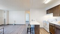 Located at 125 E 156th St in Cleveland, Ohio, this one-bedroom, one-bathroom unit offers a thoughtfully organized layout across a single floor. Light-toned wood-look flooring flows continuously throughout the space, creating a cohesive and clean aesthetic.

The living room features neutral white walls, a large window with vertical blinds that allows natural light to fill the room, and an exterior view of the surrounding neighborhood. The open feel of the space makes it versatile for various furniture arrangements.

The kitchen is efficiently designed with rich dark-toned cabinetry, both upper and lower, paired with white countertops and a white range. The kitchen opens to the main living area, promoting an easy flow between spaces.

The bedroom is a comfortable size, outfitted with the same wood-look flooring and bright white walls. A window with vertical blinds provides natural light and ventilation, while the clean, minimal design of the room offers a calm and restful environment.

The full bathroom is well-appointed with classic white tile flooring, a dark wood vanity with a white countertop and integrated sink, a mirror, and a bathtub with a cheerful striped shower curtain in soft tones of blue, pink, and beige. The overall design of the space is clean, modern, and move-in ready.