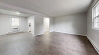 Located at 169 School St in Hamden, Connecticut, this single-floor residence offers two bedrooms and one bathroom within a well-organized, efficient layout. Consistent hardwood-style flooring flows throughout the space, complemented by a neutral gray-toned color palette and clean white trim, creating a bright and cohesive aesthetic.

The living areas are open and generously sized, featuring baseboard heating, windows that invite natural light, and a two-tone wall treatment with a chair-rail detail. The layout connects both living spaces in a practical, flowing arrangement.

The kitchen is outfitted with white cabinetry, dark countertops, a stainless steel sink, and a stainless steel electric range with a range hood — offering a clean, functional workspace with a window providing natural light.

The primary bedroom is notably spacious, featuring two corner windows with views of surrounding greenery and baseboard heating. It includes two side-by-side closets for ample storage. The second bedroom is comfortably sized with its own window and baseboard heating.

The bathroom features a full soaking tub with white tile surround and a window for natural ventilation. A connecting hallway ties the layout together efficiently, making this a well-designed, move-in-ready home.