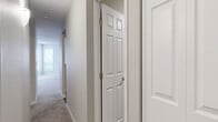 Located at Bristol Village Drive in Bloomington, MN, this two-bedroom, two-bathroom residence offers a comfortable and functional single-floor layout. The spacious living room serves as the heart of the home, featuring a tile-surround fireplace, a ceiling fan, and multiple windows that flood the space with natural light and offer views of surrounding trees. A dedicated bank of five tall windows in one area further enhances the bright, airy atmosphere throughout.

The kitchen is well-appointed with white shaker cabinetry, granite-look countertops, hardwood-style flooring, and stainless steel appliances including a range and over-the-range microwave. A built-in desk area adds convenient utility to the kitchen space.

The generously sized primary bedroom includes plush carpeting, a window with outdoor views, and access to its own private bathroom, which features a wide white vanity with ample drawer storage and a large mirror. The second bedroom is equally comfortable with soft carpet and a bright window. The second bathroom offers a pedestal sink and a full tub/shower combination.

Additional highlights include a dedicated laundry room with a stacked washer and dryer, two closets with wire shelving, and a well-connected hallway layout. Neutral tones and textured ceilings are carried throughout, creating a cohesive and welcoming environment.