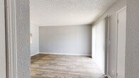 Located at 910 E 61st St in Tulsa, Oklahoma, this one-bedroom, one-bathroom unit offers a practical and well-organized single-floor layout. The combined kitchen and living room serves as the heart of the space, featuring wood-look plank flooring that extends throughout the main living areas. The living room is bright and open, with a sliding glass door that opens to a private patio overlooking lush greenery, allowing natural light to fill the room. Vertical blinds provide adjustable privacy and light control.

The kitchen is laid out in a galley style, equipped with warm wood cabinetry, white countertops, a stainless steel sink, and white appliances including a refrigerator, electric range, and dishwasher. A textured ceiling is consistent throughout the unit, adding a classic residential feel.

The bedroom is a comfortable size, finished with plush wall-to-wall carpeting and a window that brings in natural light. A dedicated closet provides convenient storage. The bathroom features wood-look flooring that ties in with the rest of the unit, a full tub-shower combination, a toilet, and a vanity with a wood-toned cabinet base. The neutral gray color palette throughout creates a clean, cohesive aesthetic.