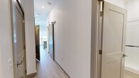 Located at 7207 McKnight Rd in Pittsburgh, PA, this thoughtfully designed one-bedroom, one-bathroom unit offers a clean, modern aesthetic throughout its single-floor layout. Light wood-look flooring flows seamlessly across every room, complementing the crisp white walls and creating a bright, cohesive atmosphere.

The hallway serves as a functional connector between spaces, featuring a stylish barn-style sliding door with brushed metal hardware. It leads to an open living area with a kitchen island boasting a butcher block countertop and slate-blue cabinetry with gold-toned hardware. A balcony door allows natural light to fill the space.

The bedroom is a well-proportioned retreat featuring dual sliding closets with built-in rods and shelving, offering generous storage capacity. Clean white walls and continued light flooring give the room a calm, airy feel.

The bathroom is finished to a high standard, showcasing a frameless glass sliding shower enclosure with white tile surround, a modern elongated toilet, and a sleek vanity with white countertop and taupe cabinetry. The consistent wood-look flooring ties the room together with the rest of the unit.

Overall, this unit presents a contemporary, move-in-ready space with quality finishes and a clean, minimalist design sensibility.