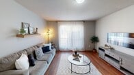 Located at 1209 W Hefner Rd in Oklahoma City, Oklahoma, this single-floor unit offers a well-organized and functional layout with warm, neutral tones throughout. The living room is a welcoming space featuring warm hardwood-style flooring, a textured ceiling, and a large window dressed with sheer curtains that invite natural light and create an airy atmosphere. The kitchen is efficiently designed with dark espresso cabinetry, granite-style countertops, a tile backsplash, and a double-basin sink, providing ample workspace and storage for everyday cooking. Appliances include a full-size refrigerator and range. The primary bedroom is generously sized, offering two closets for enhanced storage and windows with light-filtering curtains. A second bedroom provides a comfortable, quiet retreat with its own closet and natural light. The full bathroom is finished with tile flooring, a dark-framed vanity mirror, rich espresso cabinetry with a granite-topped sink, and clean, neutral wall tones. A dedicated in-unit laundry closet with a stacked washer and dryer adds everyday convenience. Hardwood-style flooring runs consistently throughout the main living areas, tying the space together with a cohesive, clean aesthetic.