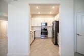 Located at 1941 Papaya Ln in Naples, Florida, this two-story home offers four bedrooms and three bathrooms across a well-organized layout. The ground floor hosts the main living areas, including a combined kitchen and living room that forms the social heart of the home. The kitchen is outfitted with white shaker-style cabinetry, a white tile backsplash, stainless steel appliances including a refrigerator with ice maker, electric range, microwave, and dishwasher, and a breakfast bar with seating for two. Large-format light tile flooring runs throughout the ground level, complementing the bright, neutral color palette. The living room features sliding glass doors that open to outdoor views, filling the space with natural light. A staircase with a wooden banister connects the floors. The upper level is more expansive and contains all four bedrooms, including a generously sized primary bedroom with plush carpeting. The remaining bedrooms are carpeted and receive natural light through windows overlooking the surrounding neighborhood. The bathrooms are clean and modern, featuring white cabinetry and light tile flooring. A dedicated laundry room with a full-size washer and dryer and overhead wire shelving adds practical convenience to the home.
