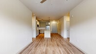 This well-appointed 2-bedroom, 2-bathroom residence in Douglasville, Georgia offers a thoughtfully designed single-floor layout. The open-concept kitchen and living area serves as the heart of the home, showcasing a granite-topped island with a built-in sink, crisp white shaker-style cabinetry, a subway tile backsplash, and a full suite of stainless steel appliances including a refrigerator, range, and built-in microwave. Pendant lighting and a track light fixture add a modern touch overhead, while wood-style plank flooring runs consistently throughout the entire space, creating a cohesive and clean aesthetic. The living area provides an open, airy feel with ample room to arrange furnishings comfortably. Both bedrooms are bright and inviting, featuring natural light from large windows with blinds and ceiling fans for added comfort. Each bathroom is outfitted with a tub-shower combo accented by white tile surround, wood-style flooring, and granite-topped vanities with brushed nickel fixtures. Two dedicated closets with wire shelving systems offer generous storage. The neutral warm-beige color palette and clean finishes throughout give the space a move-in-ready, contemporary feel.