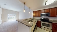 Located at 150 Erford Rd in Camp Hill, Pennsylvania, this single-floor residence offers a well-designed, open-concept layout that maximizes both functionality and comfort. The kitchen is a standout feature, boasting rich cherry wood cabinetry, granite countertops, and a full suite of stainless steel appliances including a refrigerator, electric range, and built-in microwave. Pendant lighting hangs above a peninsula-style breakfast bar that connects the kitchen to the living area, creating a seamless flow ideal for everyday living and entertaining. The living room is generously proportioned with plush wall-to-wall carpeting and a sliding glass door that floods the space with natural light and provides direct access to an outdoor area. The bedrooms are comfortably sized, each featuring neutral carpet flooring and windows that bring in additional natural light with views of the surrounding community. The bathrooms are finished with granite-topped vanities and rich wood cabinetry that complement the kitchen's design aesthetic, with tile flooring and a tub-shower combination. Throughout the residence, a neutral color palette and consistent finishes create a cohesive, move-in ready environment.