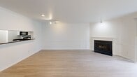 This 960 sq ft, single-floor apartment at 275 Harbor Way features 2 bedrooms and 3 bathrooms. The bright living room boasts light hardwood-style flooring, crown molding, track lighting, a classic fireplace, and a sliding glass door that fills the space with natural light. The kitchen offers white shaker cabinets, dark granite countertops, stainless steel appliances, a breakfast bar, and an adjacent in-unit washer and dryer. The 180 sq ft primary bedroom includes plush carpeting, walk-in closet with wire shelving, and an en-suite bathroom with a glass-enclosed shower. Additional bathrooms feature a jetted soaking tub combo and dark granite vanities.