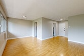 This well-appointed 1-bedroom, 1-bathroom unit at 4020 Boul St-Jean in Dollard-Des-Ormeaux offers a clean, functional layout across a single floor. Light-toned hardwood flooring flows throughout the main living areas, lending warmth and continuity to the space. The open living room is a standout feature, anchored by a wide bank of windows that frame lush, green tree views and fill the room with abundant natural light, complemented by baseboard heating beneath the windows. The neutral grey-toned walls and textured ceilings maintain a calm, understated aesthetic throughout. The kitchen is efficiently designed with white cabinetry extending to the ceiling for ample storage, a taupe tile backsplash, stainless steel appliances including a refrigerator and range, light countertops, and clean tile flooring. A pantry provides additional storage. The bedroom offers a comfortable footprint with direct access to the full bathroom and features mirrored sliding closet doors that enhance the sense of space. The bathroom is finished in neutral tones with a soaking tub, tiled flooring, and contemporary chrome fixtures. A dedicated entry foyer completes the unit, providing a clear transition point from the front door into the living area.
