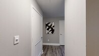 Located at 10 S Main St in the heart of downtown Memphis, Tennessee, this one-bedroom, one-bathroom residence offers a well-designed layout across a single floor. Hardwood-style flooring runs throughout, complemented by neutral gray walls and crisp white trim that create a clean, contemporary aesthetic.

The open-concept living, dining, and kitchen area serves as the centerpiece of the home. The kitchen features white cabinetry, a stainless steel refrigerator, light stone countertops, and a breakfast bar with seating — ideal for casual dining. The living area benefits from multiple windows that allow natural light to fill the space, and a ceiling fan adds comfort overhead.

A dedicated hallway connects the main living space to the private bedroom, which includes multiple windows, a ceiling fan, ample closet storage, and a calm, neutral palette. The full bathroom is outfitted with white cabinetry, a wide vanity with stone-look countertops, a large mirror, and a shower/tub combination.

Additional highlights include a laundry area, utility room, three closets, and a dedicated entrance. The overall ambiance is modern and understated, with thoughtful finishes that balance style and functionality in an efficient, well-organized floor plan.