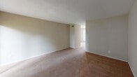 Located at 1630 Delane Ave in the 28211 zip code of Charlotte, NC, this single-floor home offers a straightforward and functional layout designed for comfortable everyday living. The open living area is anchored by a brick fireplace and features light-toned walls with neutral carpet flooring, creating a warm and inviting atmosphere. Sliding glass doors lead to an outdoor view framed by mature trees, bringing in natural light and a connection to the surrounding greenery. The kitchen is equipped with white cabinetry, a full-size refrigerator, and light hardwood-style flooring, providing a clean and practical cooking space. The bedrooms are generously proportioned, each featuring plush carpet flooring, neutral wall tones, and windows that allow natural light to filter through tree-lined views. Closet access is conveniently positioned within the bedroom areas. The bathrooms include a full bath with a tiled tub-shower combination, marble-style tile flooring, and a single vanity with ample counter space, while a second bath features a wide vanity countertop with a large wall mirror and louvered cabinet accents. Throughout the home, textured ceilings, consistent neutral tones, and a cohesive design language contribute to a clean, move-in ready presentation.