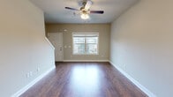 Located at 232 Epps Bridge Rd in Athens, GA, this two-story home offers five bedrooms and three bathrooms spread across two well-proportioned floors. The main level features an open-concept living room with rich hardwood-style flooring, a ceiling fan with light fixture, and a front-facing window that brings in natural light. The living area flows seamlessly toward the staircase and into the kitchen, which is a standout feature of the main floor. The kitchen is equipped with dark wood cabinetry, black appliances, recessed lighting, a pendant chandelier, and a large granite-topped island with a built-in sink — ideal for both cooking and gathering. The upper level houses the bedrooms, including a generously sized primary bedroom with a ceiling fan, a closet, and a window overlooking greenery. Additional bedrooms are carpeted, neutrally painted, and well-lit, offering comfortable and functional spaces. The bathrooms are consistently finished with granite vanity countertops, dark wood cabinetry, and tub-shower combinations. Throughout both floors, neutral warm-toned walls, white trim, and consistent flooring choices create a cohesive and clean aesthetic. Carpeted stairs connect the two levels, contributing to the home's practical and comfortable character.