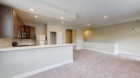 Located at 101 Continental Ave in Coatesville, PA, this well-appointed one-bedroom, two-bathroom residence offers a thoughtfully designed single-floor layout. The open-concept living and kitchen area serves as the heart of the home, featuring rich dark cabinetry, white countertops, stainless steel appliances including a gas range, built-in microwave, and dishwasher. Recessed lighting illuminates the kitchen, which flows seamlessly into the carpeted living area. Multiple windows dressed with horizontal blinds fill the living space with natural light and offer views of the surrounding neighborhood. A glass-paneled entry door adds architectural interest and further enhances the brightness of the space. The generously sized bedroom includes access to a dedicated closet and connects conveniently to a full bathroom. The full bathroom is outfitted with a tub/shower combination, dark wood vanity cabinetry, white countertop, and tile flooring. A second bathroom and a dedicated laundry area round out the functional layout. Neutral tones throughout — including soft gray walls, white trim, and plush carpeting — create a clean, cohesive aesthetic. An open staircase with a half-wall railing connects to the entry level below, adding a sense of openness to the overall design.