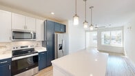 Located at 200 Brooklawn St in Farragut, TN, this well-appointed 2-bedroom, 2-bathroom single-floor residence offers a thoughtfully designed layout with modern finishes throughout. The open-concept kitchen and living area serves as the heart of the home, showcasing a striking two-tone cabinetry design with crisp white upper cabinets and bold navy lowers, complemented by a marble-style tile backsplash, quartz countertops, a central island with pendant lighting, and a full suite of stainless steel appliances. Light wood-style flooring runs throughout the main living areas, adding warmth and continuity. The living room receives generous natural light through large windows with outdoor views. Both bedrooms are comfortably sized, with the primary bedroom featuring plush carpet, a ceiling fan, and ample natural light from a large window. The second bedroom also includes carpet and a ceiling fan. The bathrooms are finished cleanly in white with wood-look flooring and brushed gold fixtures, including a tub-shower combination. A dedicated laundry room houses a full-size washer and additional storage. Two closets provide practical storage solutions throughout the residence, rounding out this functional and stylish home.
