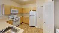 Located on Silver Creek Drive in Perrysburg, Ohio, this single-floor residence offers a practical and well-organized layout designed for comfortable everyday living. The open floor plan connects the kitchen and living areas, creating a cohesive and accessible flow throughout the unit.

The kitchen is equipped with light maple cabinetry offering generous storage, light-toned countertops, and white appliances including a gas range, over-the-range microwave, and refrigerator. Tile flooring runs through the kitchen, adding durability to this high-use area. A peninsula counter opens toward the adjacent living and dining space, enhancing the sense of connection between rooms.

The living area is carpeted and features a sliding glass door that allows natural light to fill the room while providing access to an outdoor view. The neutral color palette throughout the space contributes to a clean, understated ambiance.

The bedrooms are carpeted and finished with neutral walls. One bedroom includes a large closet with built-in wire shelving and organizers, offering practical storage solutions. A window in this room brings in additional natural light.

The bathroom features tile flooring, a light wood vanity with a broad countertop, an integrated sink, a large mirror, and chrome fixtures and towel bars, presenting a tidy and functional design.