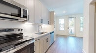 This well-designed 1-bedroom, 1-bathroom unit offers a smartly organized single-floor layout that maximizes every square foot. Light wood-look flooring runs consistently throughout, creating a cohesive and clean aesthetic across all rooms.

The kitchen is a standout feature, equipped with a full suite of stainless steel appliances including a refrigerator, electric range, built-in microwave, and dishwasher. Two-tone cabinetry pairs white upper shaker cabinets with warm wood-toned lower cabinets, accented by matte black hardware. A granite-look countertop and classic subway tile backsplash complete the contemporary design.

The living area benefits from large windows and a sliding glass door that invite generous natural light and provide outdoor views. A ceiling fan adds comfort and functionality to the space.

The bedroom is a cozy yet practical retreat, featuring a ceiling fan, a window for natural light, and access to a dedicated closet with built-in shelving and hanging rods.

The bathroom is finished with the same attention to detail, offering a glass-enclosed shower, a granite-topped vanity with white cabinetry and matte black fixtures, and wood-look flooring that ties the space together.

Throughout, the unit maintains a bright, neutral palette with crisp white walls, recessed lighting, and clean architectural lines, creating a fresh and modern living environment.