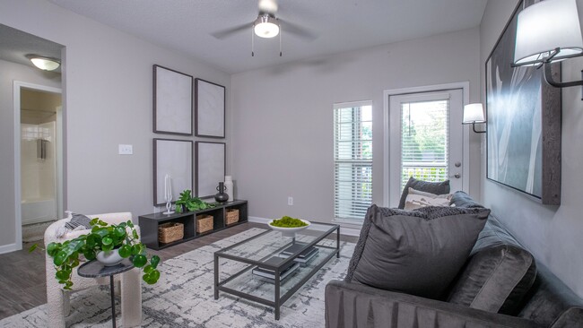 Find ultimate comfort in our living room, where a glass door invites you to a serene screened-in patio. - 12th and James Luxury Apartments