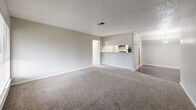 Located in Houston's 77084 zip code, this single-story, 3-bedroom, 2-bathroom home offers a practical and comfortable layout. The living room greets you at the entrance with plush carpet flooring, a large window with blinds that invites natural light, and a textured ceiling with a central air vent, creating a bright and welcoming atmosphere.

The kitchen is efficiently designed with a galley-style layout, featuring wood-look vinyl flooring, white cabinetry, a stainless steel sink with countertops, and black appliances including a refrigerator and range with dishwasher.

The spacious primary bedroom includes ceiling fan with light fixture, soft carpet flooring, and a window with blinds, offering a comfortable retreat. The additional bedrooms are similarly appointed with carpet flooring, ceiling fans, and windows that provide natural light and ventilation.

Both bathrooms are fitted with wood-look vinyl flooring, a tub-shower combination with tiled surrounds, and vanities with granite-style countertops. Closet spaces include built-in shelving and hanging rods for organized storage. Throughout the home, neutral tones and textured ceilings create a clean, consistent aesthetic.