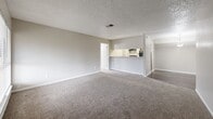 Located in Houston's 77084 zip code, this single-story, 3-bedroom, 2-bathroom home offers a practical and comfortable layout. The living room greets you at the entrance with plush carpet flooring, a large window with blinds that invites natural light, and a textured ceiling with a central air vent, creating a bright and welcoming atmosphere.

The kitchen is efficiently designed with a galley-style layout, featuring wood-look vinyl flooring, white cabinetry, a stainless steel sink with countertops, and black appliances including a refrigerator and range with dishwasher.

The spacious primary bedroom includes ceiling fan with light fixture, soft carpet flooring, and a window with blinds, offering a comfortable retreat. The additional bedrooms are similarly appointed with carpet flooring, ceiling fans, and windows that provide natural light and ventilation.

Both bathrooms are fitted with wood-look vinyl flooring, a tub-shower combination with tiled surrounds, and vanities with granite-style countertops. Closet spaces include built-in shelving and hanging rods for organized storage. Throughout the home, neutral tones and textured ceilings create a clean, consistent aesthetic.