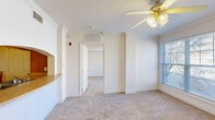 Located at 515 W Franklin St in Richmond, VA, this two-bedroom, two-bathroom residence offers a practical and well-organized single-floor layout. The living area features plush wall-to-wall carpeting, crown molding, and a ceiling fan with light fixture, creating a comfortable and bright space. A pass-through counter connects the living area to the galley-style kitchen, which is outfitted with warm wood cabinetry, light tile flooring, a double sink, and white appliances including a refrigerator and range. Both bedrooms are carpeted and equipped with ceiling fans, and each receives natural light through large windows fitted with blinds that offer views of the surrounding neighborhood. The primary bedroom provides a generous amount of space, while the second bedroom is well-suited for a guest room or home office. A dedicated closet offers additional storage within the unit. Both bathrooms feature light tile flooring, and at least one includes an extended vanity with wood cabinetry and a tub-shower combination with full tile surround. A hallway connects the rooms efficiently, completing this thoughtfully arranged and move-in-ready residence in the heart of Richmond.