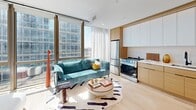 Located at 395 Carroll St in Brooklyn's Carroll Gardens neighborhood, this efficiently designed one-bedroom, one-bathroom unit maximizes its compact footprint through thoughtful layout and modern design. The open-plan living area serves as the heart of the space, where light hardwood flooring and floor-to-ceiling windows flood the room with natural light while offering sweeping urban views of the Brooklyn skyline. The integrated kitchen is seamlessly incorporated into the living area, featuring warm wood cabinetry paired with white upper cabinets, stainless steel appliances including a gas range and refrigerator, and clean-lined countertops. The living area comfortably accommodates seating and entertaining space. The bedroom, finished in soft neutral tones, offers a cozy and restful retreat with light-toned walls and warm natural light. The well-appointed bathroom showcases premium finishes, including large-format stone-look wall tiles, a soaking tub with glass shower enclosure, matte black fixtures, a floating wood vanity with an undermount sink, and terrazzo-style flooring, creating a refined, spa-like aesthetic. Overall, the unit combines contemporary design with functional urban living.