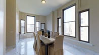 Located in the heart of Center City Philadelphia, this refined residence at 135 South 19th Street offers a sophisticated living experience with thoughtfully curated finishes throughout. The space is situated on an upper floor, providing sweeping views of the Philadelphia skyline through oversized, black-framed windows that flood the interior with abundant natural light.

The dining area is a standout feature, showcasing gleaming polished marble tile flooring that lends a timeless, upscale character to the space. The room is framed by classic architectural wall paneling with refined molding details, adding a sense of depth and elegance to the neutral, creamy walls. The high ceilings further enhance the airy, open atmosphere throughout.

Large windows on multiple walls ensure panoramic city views from nearly every angle, creating a dramatic urban backdrop that enriches the ambiance of daily living. The overall aesthetic is clean, bright, and classically styled — balancing traditional architectural details with a modern sensibility. The layout flows naturally, offering a sense of spaciousness well-suited for both comfortable everyday living and gracious entertaining. This Center City address places residents steps from Philadelphia's finest dining, cultural institutions, and professional corridors.